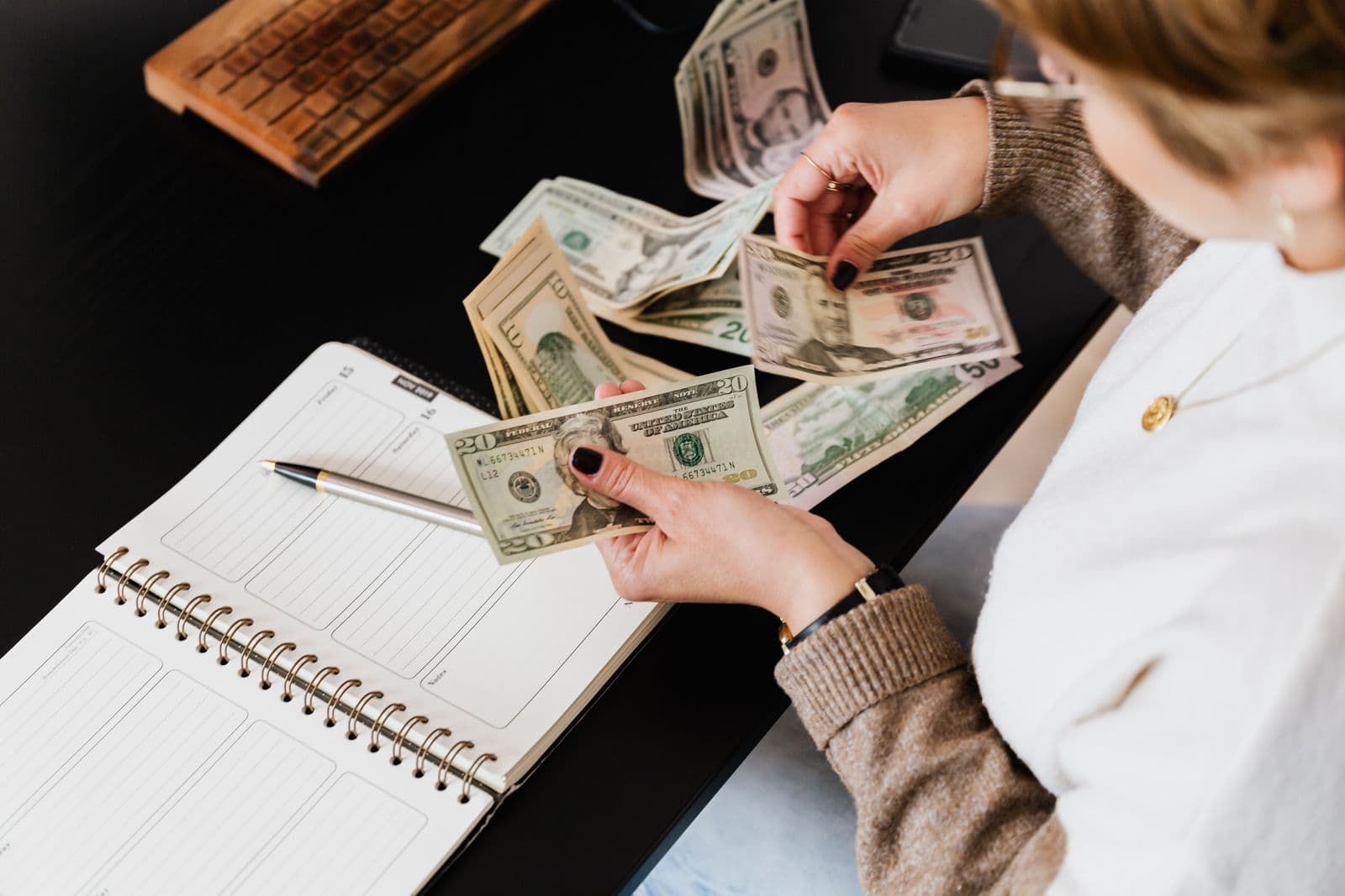An owner counting the week's takings beside an open planner